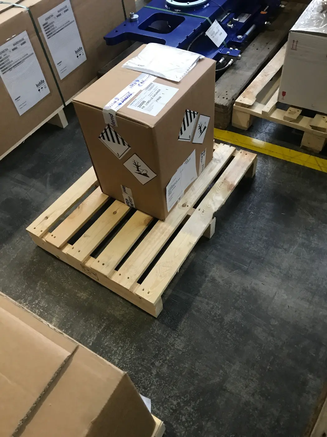 Pallet met verpakte gevaarlijke goederen en gevarenetiketten